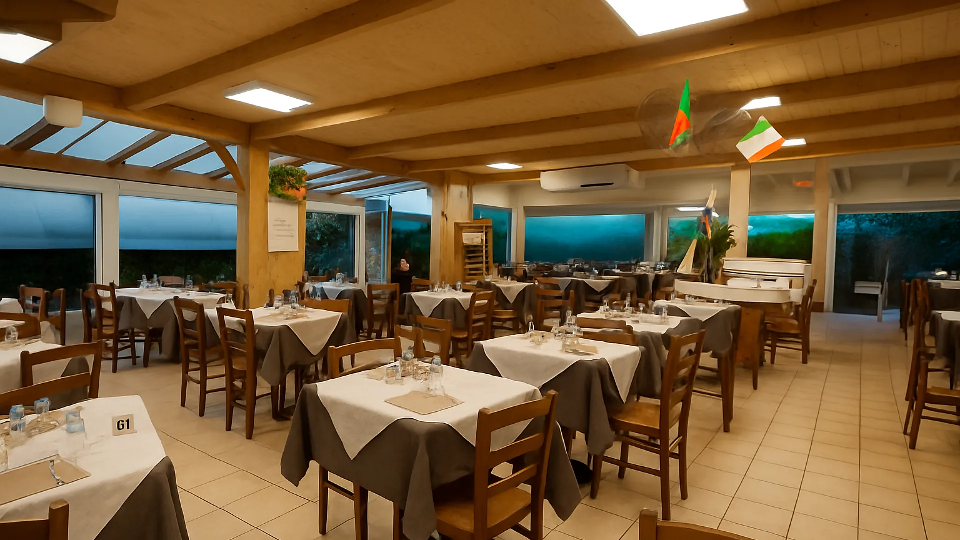 La sala della Trattoria da Corrado, tavoli apparecchiati sotto la veranda di legno